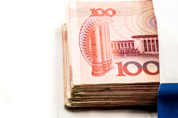 pile of chinese yuan bankotes in a paper bag on white