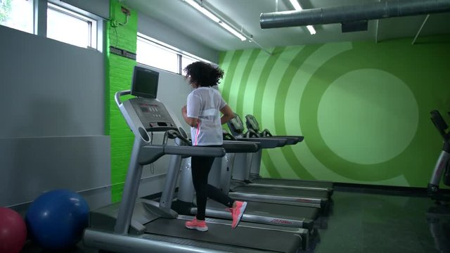 African American woman working on a treadmill in the gym