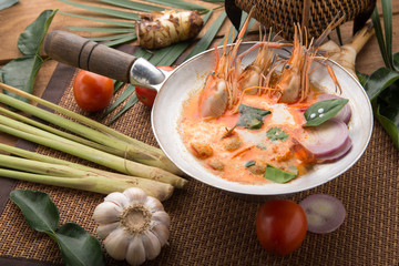 Tom yam kong or Tom yum, Tom yam is a spicy clear soup typical in Thailand Cuisine. Tom yam kong on wooden table. Thai food.