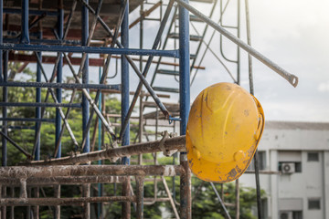 The old yellow safety helmet at construction site in dark tone