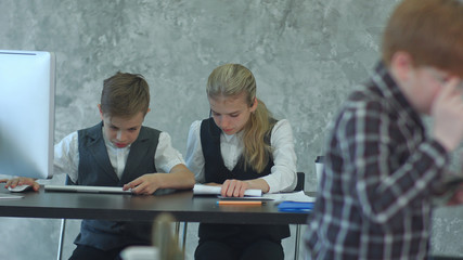 Kids working with documents and laptop in office