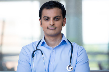 Closeup portrait of friendly, smiling confident male doctor, healthcare professional with stethoscope around neck, arms crossed.