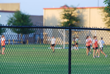 football field and players behind chain link fence