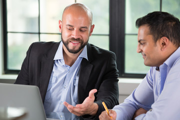 Closeup portrait of two people having business discussion on laptop, isolated indoors office window background