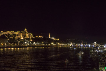 Fototapeta na wymiar Night Budapest at the river Danube. Buda Castle (Royal Palace) and Chain bridge (Szechenyi lanchid) on background. Hungary