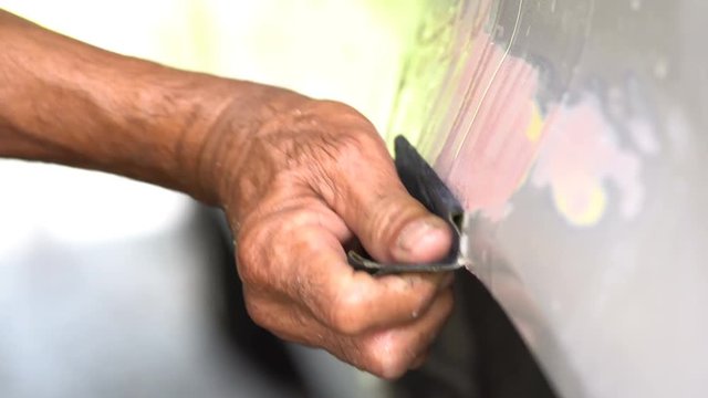 Auto mechanic polishing the car for painting
