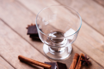 Anise and cinnamon sticks near empty glass
