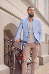Fototapeta na wymiar Portrait of elegant bearded guy near the retro bicycle.