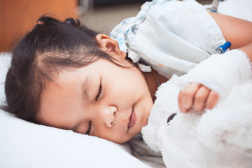 Fototapeta na wymiar Sick asian child girl is sleeping in the hospital