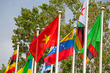 Flags of the world happily blowing in the wind .