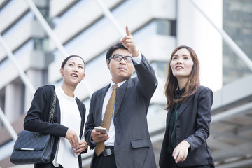 Asia businessman pointing and looking up for the future with businesswoman, vintage color tone.