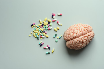 Colorful medicine in tablets and capsules with brain model on table