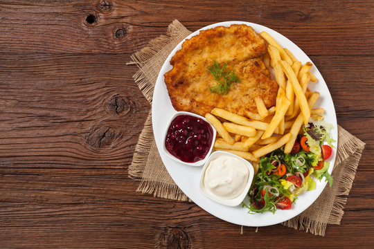 Chicken schnitzel, served with fries and salad.