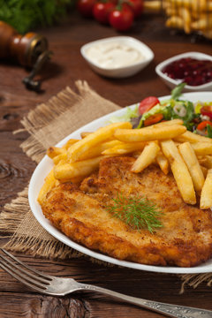 Chicken schnitzel, served with fries and salad.