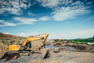 Fototapeta na wymiar Highway construction site building details with excavators loading dumper trucks, bulldozer, scoop working and engineers