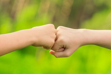 Two hands hitting each other with their fists