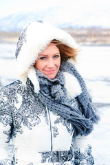 Beautiful portrait of a smiling woman in winter with a hood and scarf