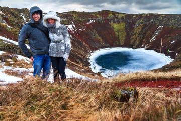Tourist couple having fun on the top of the Kerid volcanic crater in Iceland © dennisvdwater