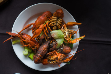 Big plate of tasty boiled crayfish closeup on wooden table, seafood dinner, nobody