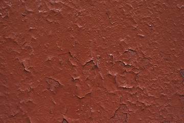 Peeling rough red paint over old cracked pain on a metal surface  , texture, background