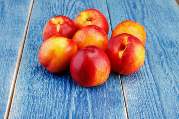 Group of whole nectarine fruits on the wooden background. Peaches are popular fruits for summer