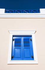 Naklejka na ściany i meble Window with blue shutters against a wall background on the island of Santorini, Greece, Europe.