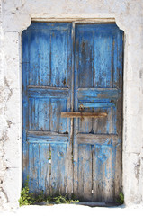 Bright blue old weathered door on the island of Santorini, Greece, Europe.
