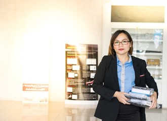 Asian women holding documents in an office. She works in car and insurance.