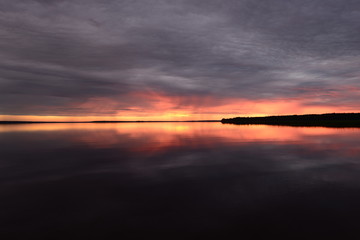 Sunset light up to the horizon line above the water surface of the lake