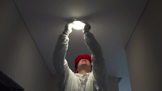 professional electrician man mount circle led light into ceiling hole