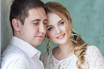 A loving beautiful couple hugging and kissing by the window
