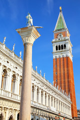 Fototapeta na wymiar Close view of St Mark's Campanile, St Theodore of Amasea statue and Biblioteca in Venice, Italy.