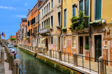 Fototapeta na wymiar Row of houses along narrow canal in Venice, Italy