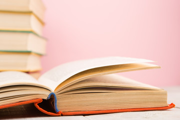 education and wisdom concept - open book on wooden table, color background