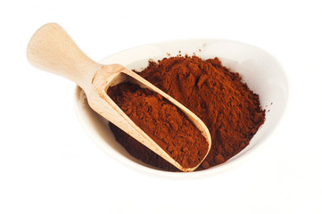 Heap of cocoa powder with wooden scoop isolated on the white background
