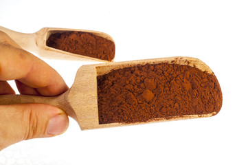Heap of cocoa powder with wooden scoop isolated on the white background