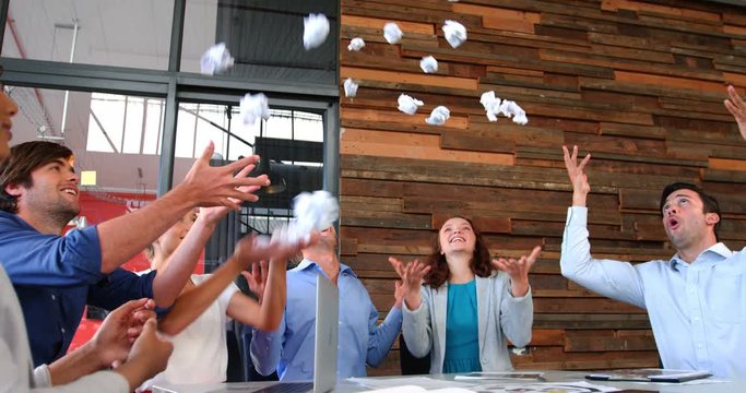 Business executives throwing crumpled paper in air