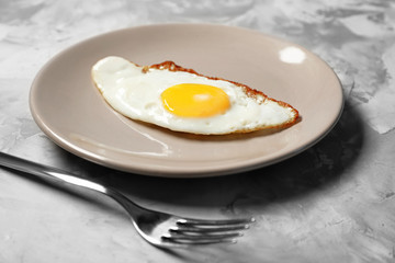 Plate with delicious over easy egg on table