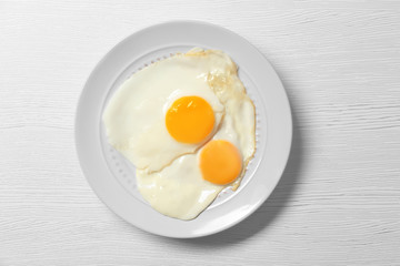 Delicious breakfast with over easy eggs on wooden background