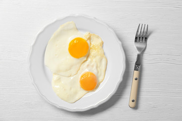 Delicious breakfast with over easy eggs on wooden background