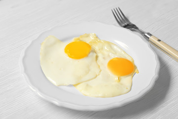 Delicious breakfast with over easy eggs on wooden background