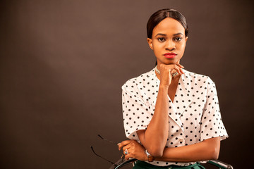 Portrait of beautiful african american woman on a brown background.