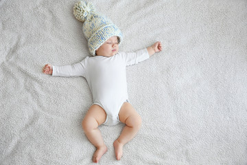 Cute little baby sleeping on plaid at home
