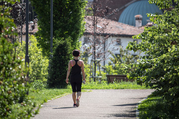 sportive woman with headphones, she is training at the park
