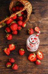 Strawberry smoothie or milkshake in jar and basket on old rustic background