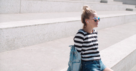 Young woman with headphones enjoying time in a city.