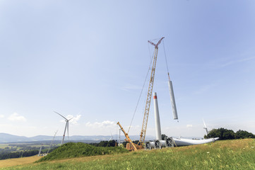 Fototapeta na wymiar Building and assembling a construction windmill by a crane