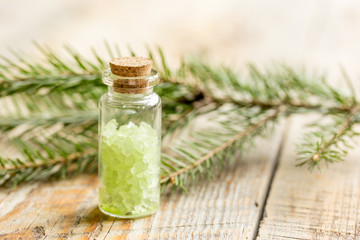 Spruce spa with organic salt in bottles on wooden table background