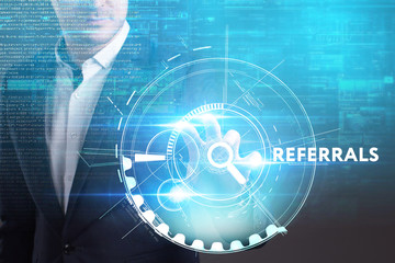 Business, Technology, Internet and network concept. Young businessman working on a virtual screen of the future and sees the inscription: Referrals