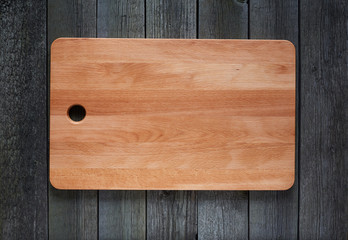 Cutting board with space for text on old wooden background. Close-up